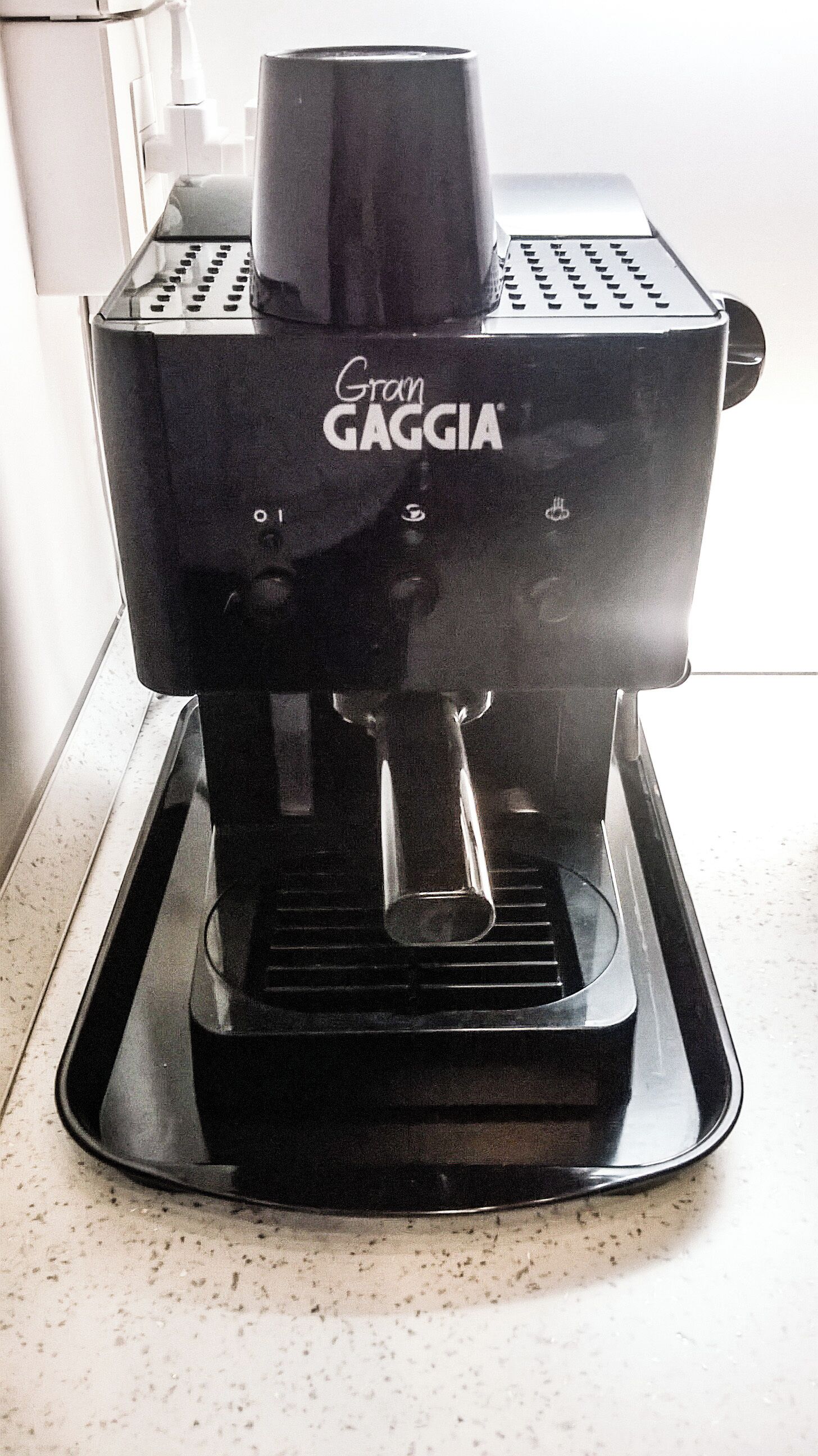 Uma máquina de café expresso Gaggia sobre uma bancada de cozinha.
