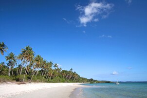 On the beach, white sand, sun loungers, beach towels