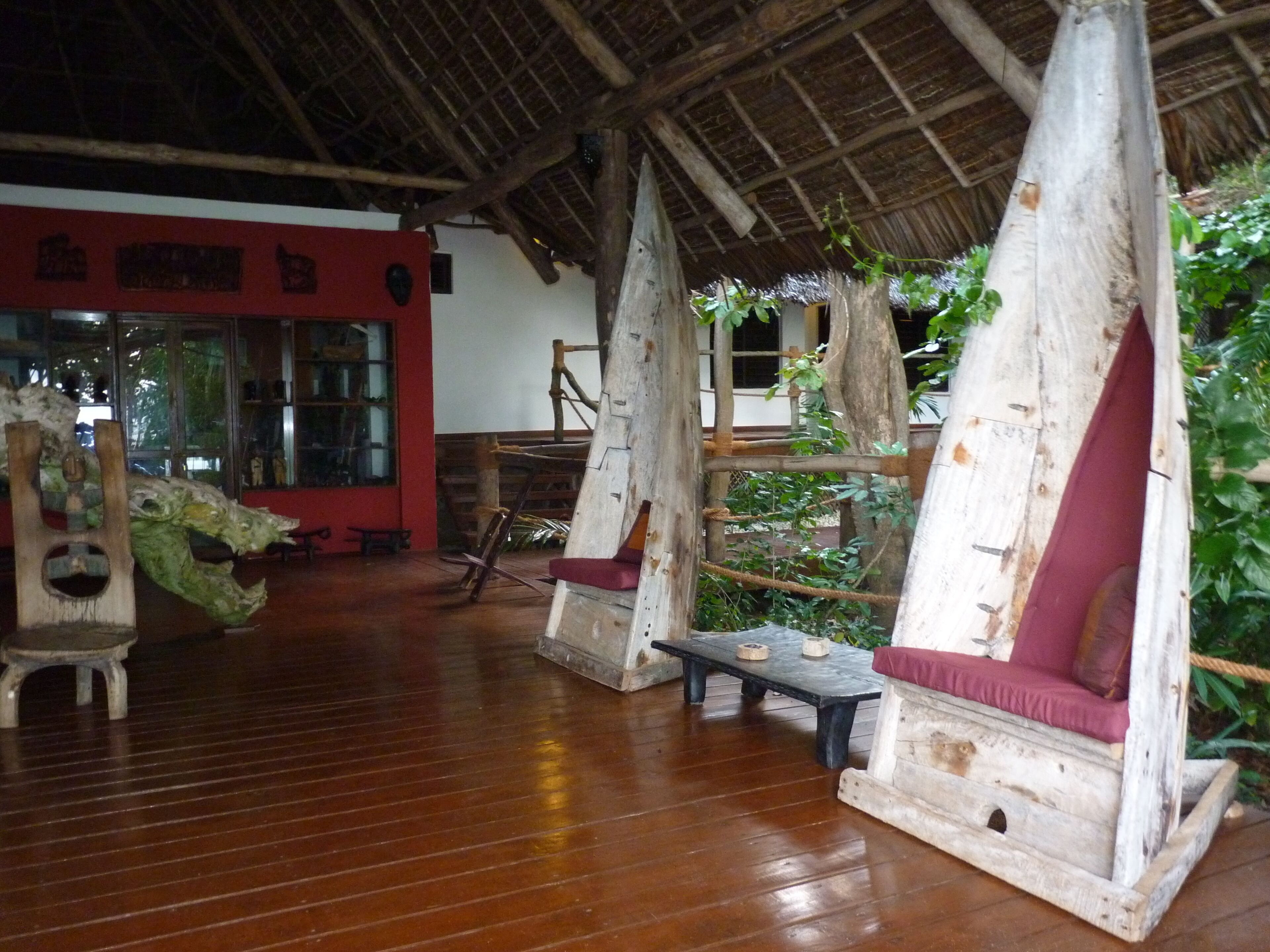 Un interior rústico con muebles de madera y techo de paja.
