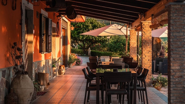An outdoor patio with a brick floor, wicker furniture, and a table with chairs. - Bb La Mortella With Pool (Roccadaspide)