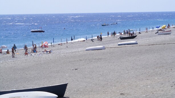 A beach with boats, umbrellas, and people. - House Between Etna and the sea Near Taormina (Santa Venerina)