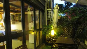 An outdoor patio with a wooden table and chairs, a bench, and a lantern. - House Between Etna and the sea Near Taormina (Santa Venerina)
