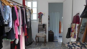 A room with a clothing rack, a chair, a table, and a window. - Beautiful Country Home on Syros Island, Greece (Syros)