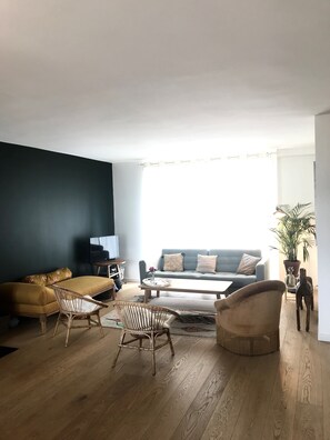 Relax in this stylish living room with a sofa, coffee table, and wicker chairs.