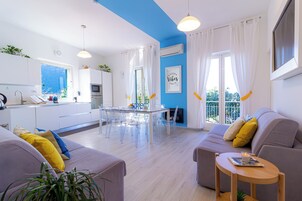 Una sala de estar moderna con sofá, una mesa de centro y un comedor con mesa y sillas.