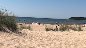 A sandy beach with people sunbathing and swimming. - Kotimaailma Apartments Pori City Center (Pori)