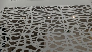 Un intérieur moderne avec des cloisons blanches aux formes géométriques et une vue sur le ciel grâce à de grandes fenêtres.