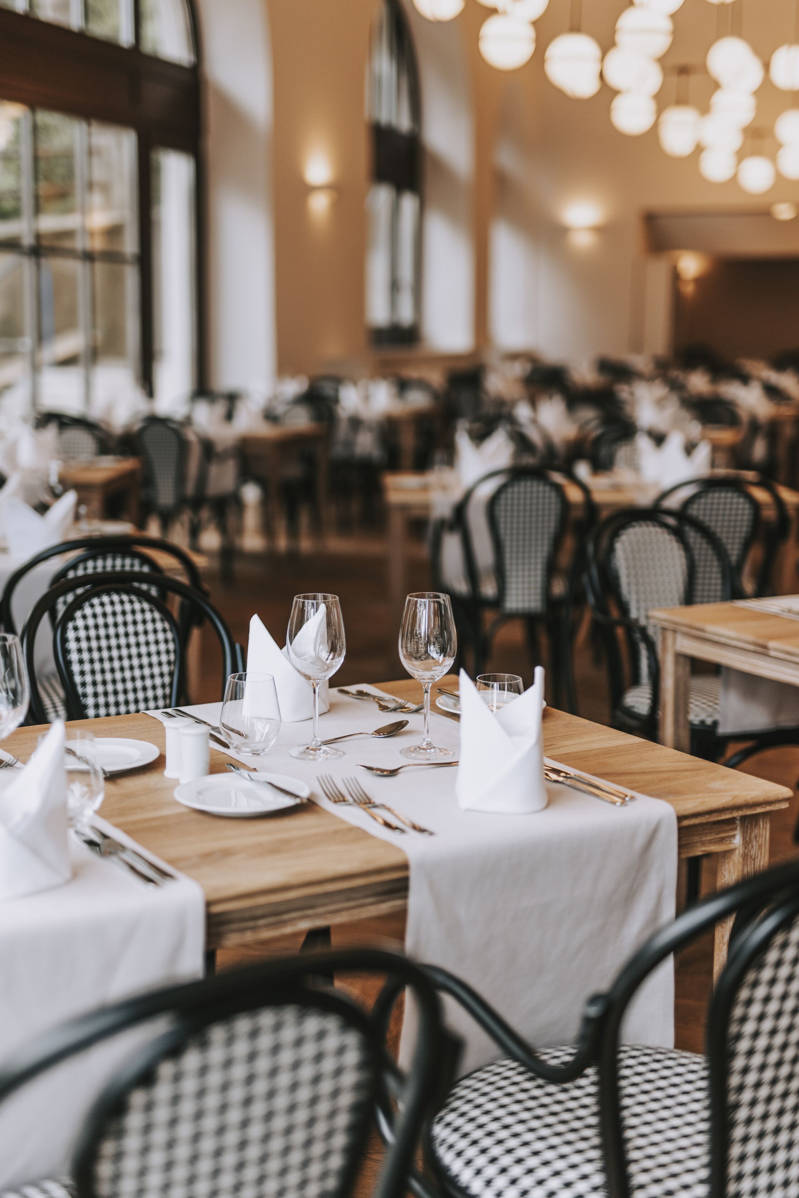Ein Restaurant mit gedeckten Tischen, karierten Stühlen und einer gemütlichen Atmosphäre.