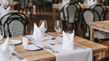 Ein Restaurant mit gedeckten Tischen, karierten Stühlen und einer gemütlichen Atmosphäre.