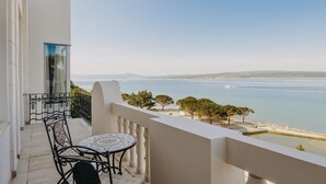 Un balcon avec une table et des chaises donnant sur une vue sur la côte.