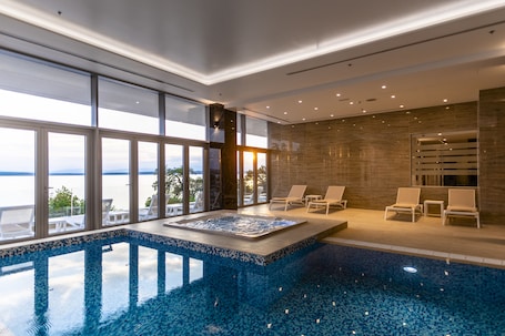 Una piscina techada, sillones reclinables de piscina