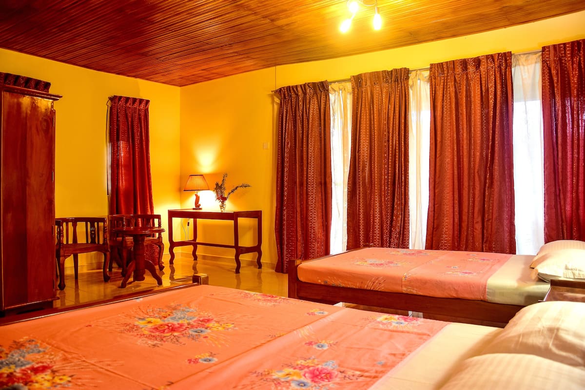 Un dormitorio con dos camas, muebles de madera y una pared amarilla.