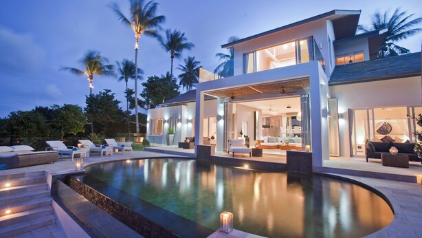 A modern house with a swimming pool, outdoor seating, and a well-lit interior. - Villa Sarasuz is a 5 Star Luxury Villa Located on the Prestigious Bophut Hill (Koh Samui)
