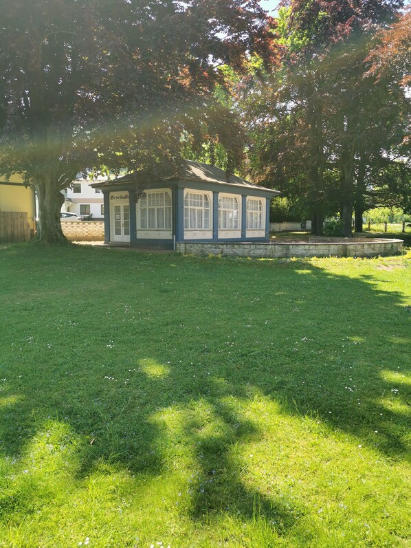 A small building with a stone wall and a grassy lawn. - Schöne Ferienwohnung in Jugendstilvilla (Tabarz)