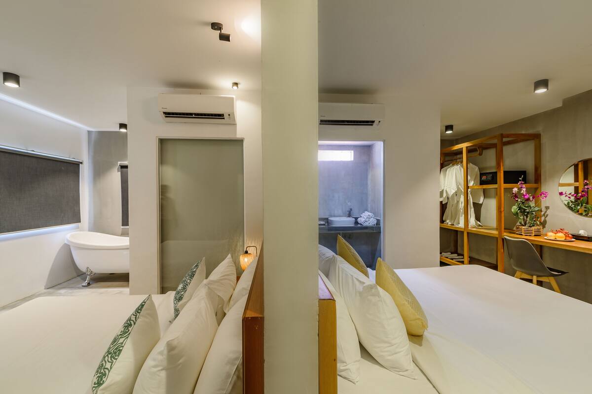 Habitación de hotel moderna con una cama grande, baño independiente, escritorio con silla y armario.