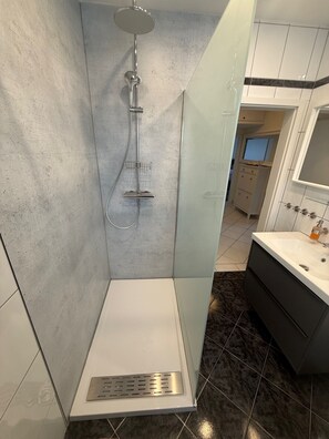 Een bad/douchecombinatie, een haardroger, handdoeken, zeep