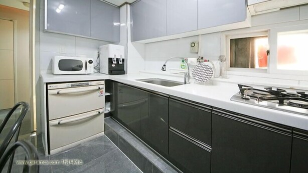 Una cocina moderna con microondas, cafetera, lavabo y estufa.