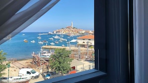 Un pueblo costero con vistas al mar, barcos y una torre destacada.