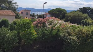 A coastal residential area with houses, dense greenery, and a clear view of the sea and mountains in the background. - Villa Gai Soleil, quiet location 500 m from Port Santa Lucia and beaches (Saint-Raphaël)