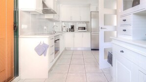 A modern kitchen with white cabinetry, a stainless steel refrigerator, and a microwave. - Semiramis 4 - Altea, Costa Blanca (Altea)