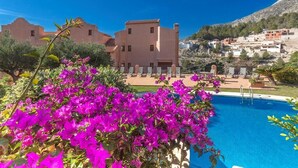 A poolside view with a building in the background, surrounded by greenery and mountains. - Semiramis 4 - Altea, Costa Blanca (Altea)