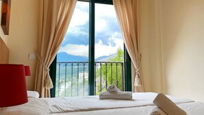 A hotel room with two beds, a red lamp, and a view of mountains through large windows. - Semiramis 7 - Altea, Costa Blanca (Altea)