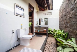 A compact bathroom with a toilet, sink, and shower. - Gardenia Gardensbest Breakfast in Bali (Ubud)