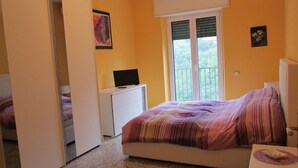 A bedroom with a bed, a TV on a small table, and a window with blinds. - Wonderful Amalfi Coast Apartment Overlooking the sea With Free Wifi and Parking (Vietri sul Mare)