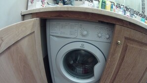 A compact washing machine in a kitchen cabinet with a control panel and a door lock. - Wonderful Amalfi Coast Apartment Overlooking the sea With Free Wifi and Parking (Vietri sul Mare)