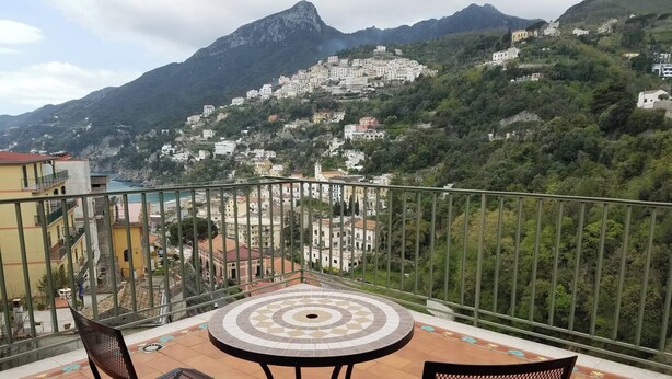 A balcony with a tiled floor, two metal chairs, and a round table with a patterned center. - Wonderful Amalfi Coast Apartment Overlooking the sea With Free Wifi and Parking (Vietri sul Mare)