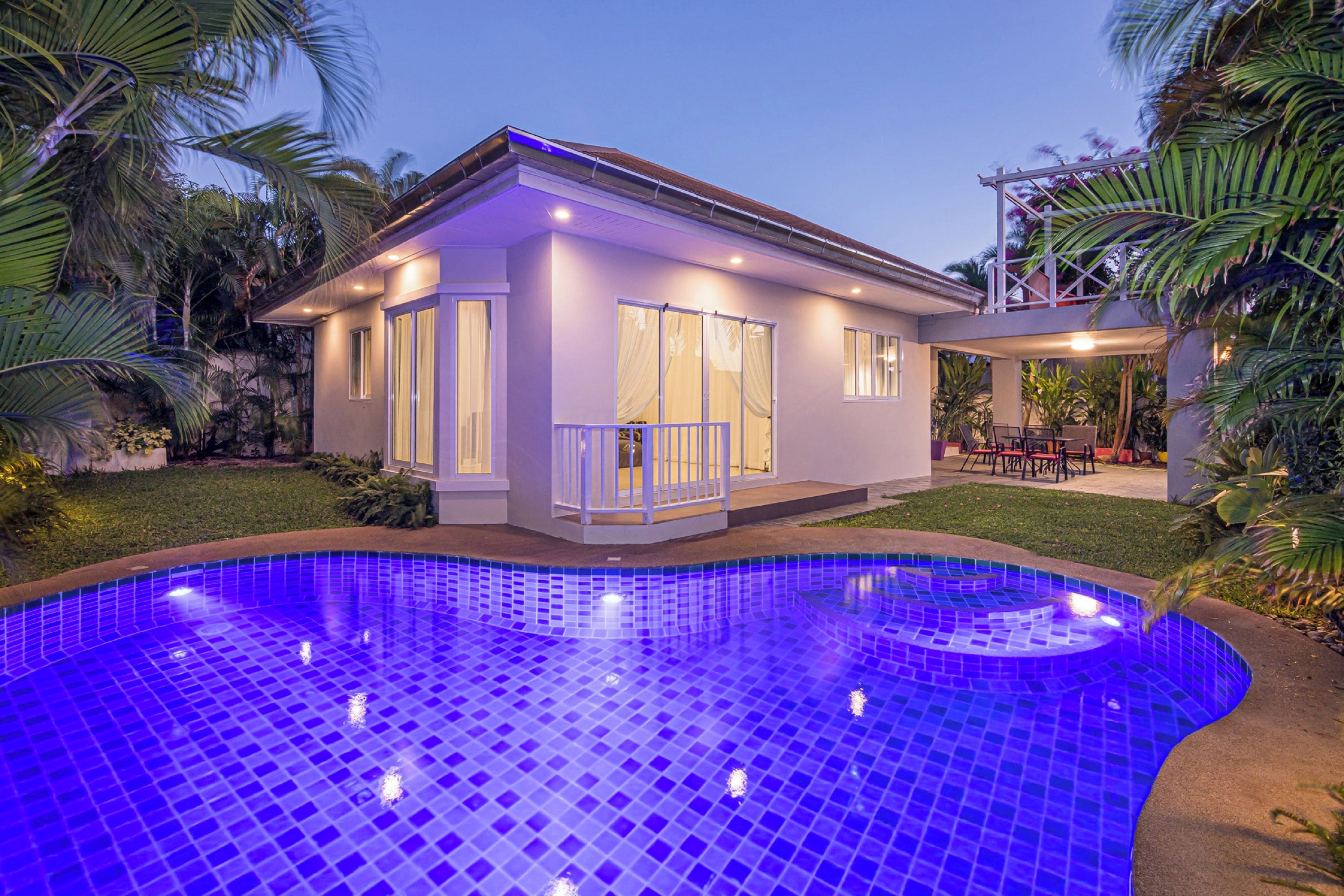A modern house with a swimming pool, large windows, and a patio area.