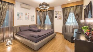 A modern bedroom with a large bed, a desk, and a chair.