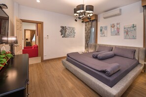 Een moderne slaapkamer met een bed, een bureau en een rode bank.