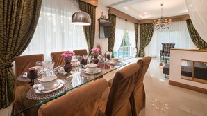 Comedor con una mesa de vidrio dispuesta para seis personas, rodeado de sillas tapizadas en tono marrón.