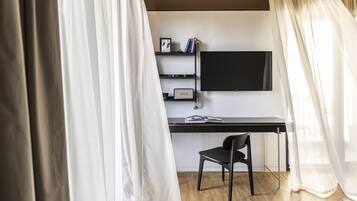 A modern room with a desk, chair, and a mounted TV.