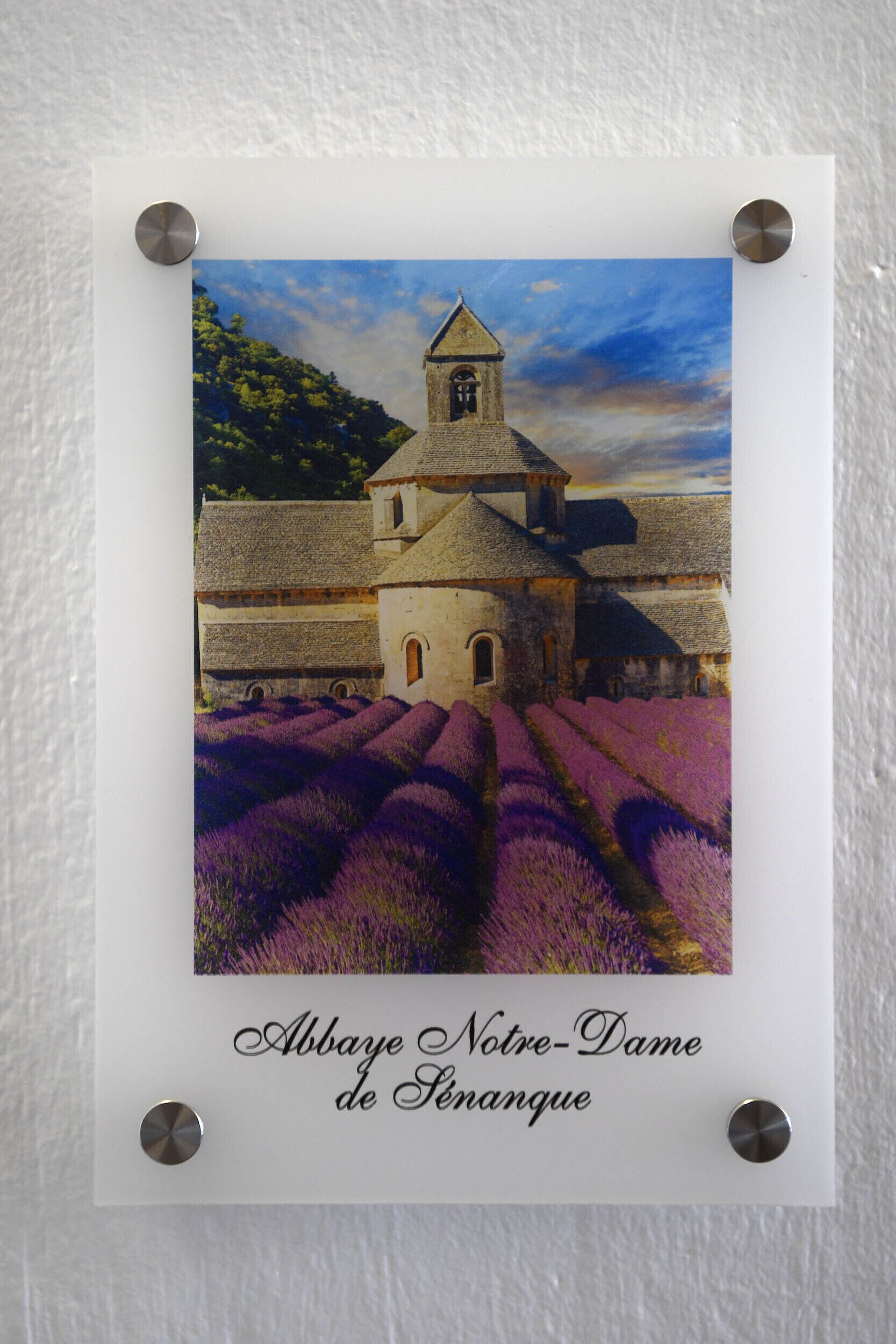 Une photographie encadrée représentant une église avec un clocher et des champs de lavande.