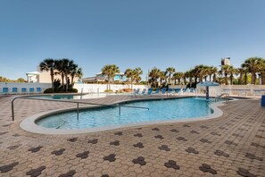 A swimming pool with lounge chairs and palm trees. - Majestic Beach 2-1501 - 1977694 (Panama City Beach)