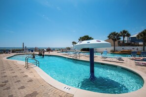 A swimming pool with a 3 FT depth marker, surrounded by lounge chairs and a view of the ocean. - Majestic Beach 2-1501 - 1977694 (Panama City Beach)