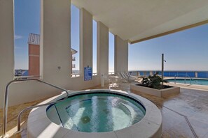 A hot tub with a view of the ocean, surrounded by lounge chairs and a pool. - Palazzo 1604 (Panama City Beach)