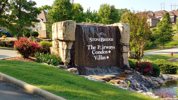 A sign for Stonebridge The Fairways Condos and Villas with a waterfall feature.