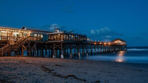 A pier extending into the ocean with a building on it.