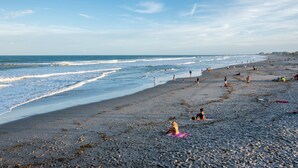 A beach with people walking and relaxing.