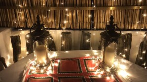Una mesa decorada con velas y luces de cadena, con un fondo de madera rústica.