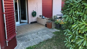 A courtyard with a sliding glass door, a small table, and a potted plant. - Large Studio Near Epfl And Lausanne City Center (Ecublens)