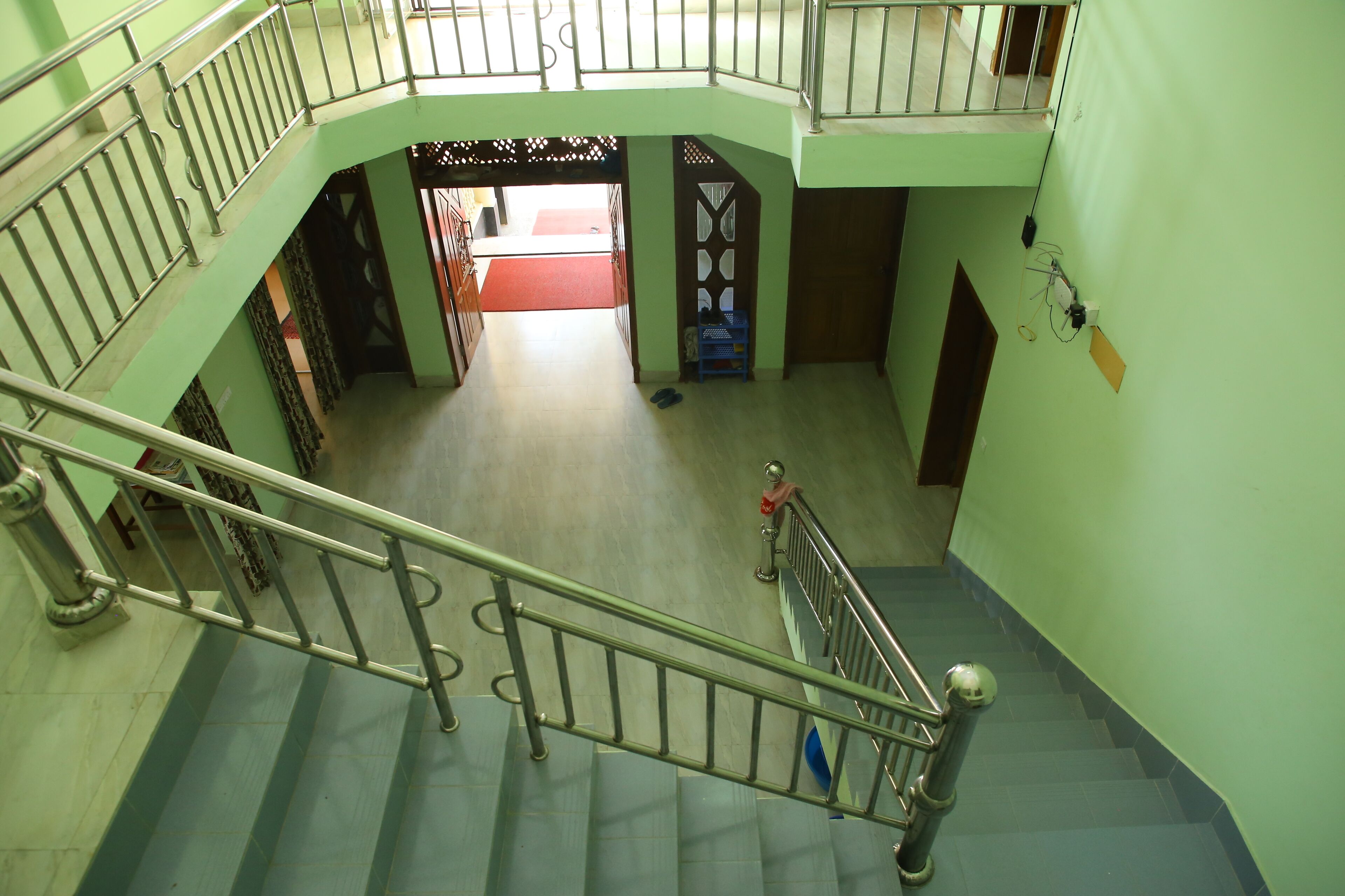 A multi-level interior with a staircase, a red carpet, and a blue chair.