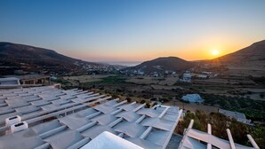 A coastal landscape with a sunset, white buildings, and a terrace with sun loungers. - Villa Amphitrite With Amazing sea View and Private Swimming Pool (Paros)