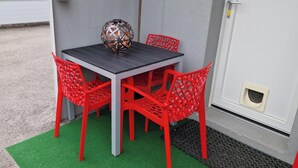 A table with four red chairs, a decorative sphere, and a green mat.