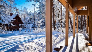 A wooden cabin with a porch and a snow-covered landscape. - Baan Hakuba (Hakuba)