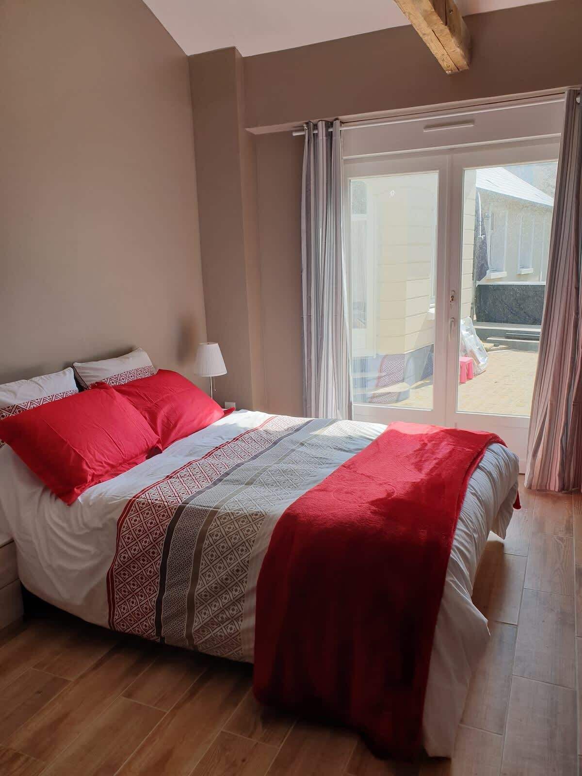 Een slaapkamer met een bed, een lamp en uitzicht.