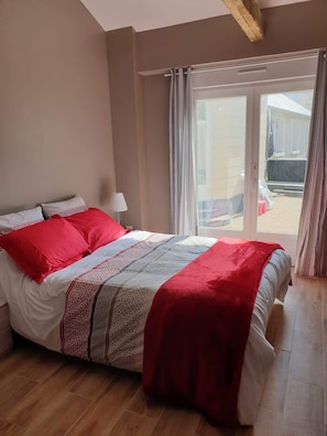 Une chambre à coucher avec un lit, une lampe et une vue sur l’extérieur.